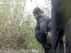 Couple peeing outdoors