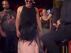 Gagged brunette tormented in public bar