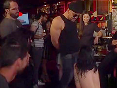 Gagged brunette tormented in public bar
