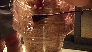 Male Slave Bound In Cling Wrap Gets Riding Crop Cbt By Two Gorgeous Femdoms