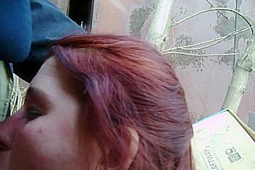 Mature blond gives a public blowjob