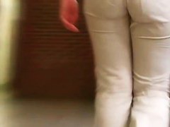 Street booty catches a woman flexing her butt in tight jeans