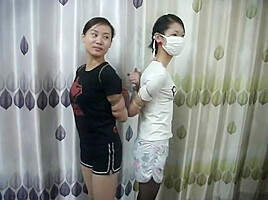 Two Chinese Girls Tied, One Wearing Cloth Mask