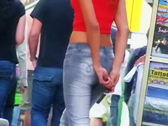candid skinny tanned ad girl standing on the street in tight clothes